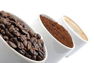Kaffebönor, kaffepulver och en kaffekopp